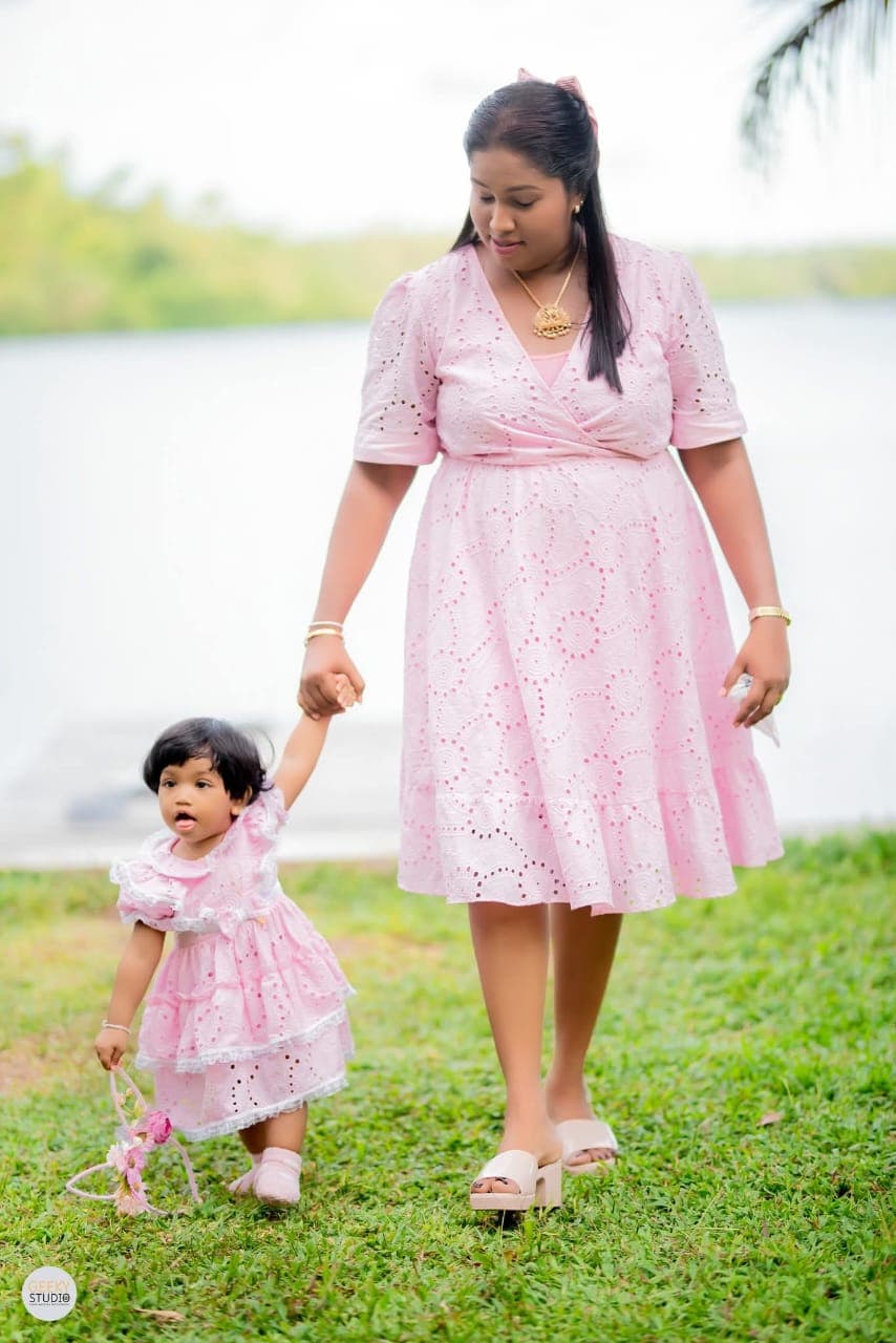 Mother and daughter in matching pink dresses walking by the lake at AquaTrek celebration event
